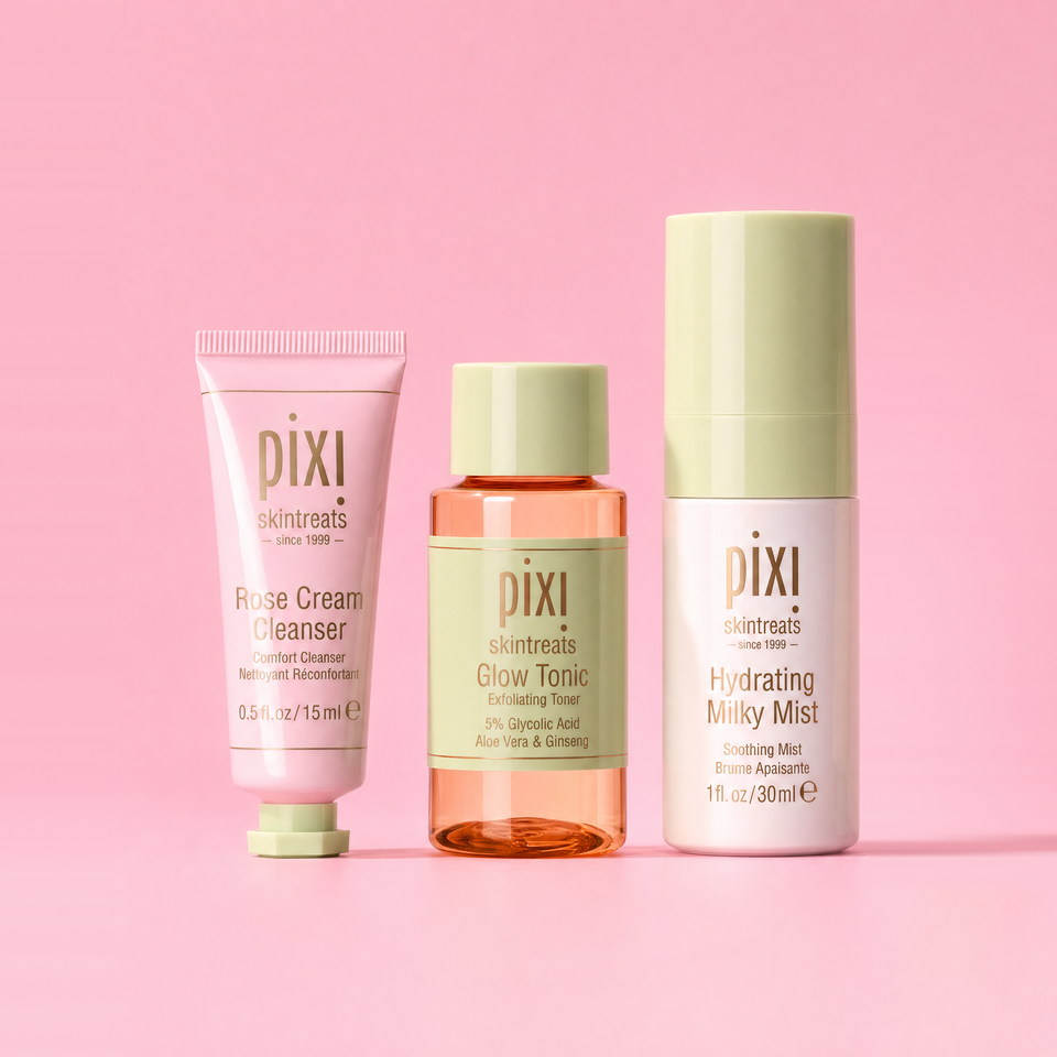 Three Pixi skincare products arranged on a solid pink background: a pink cleanser tube, an amber glow tonic bottle with a pale green cap, and a white hydrating mist bottle with a pale green cap. Visible brand text reads pixi skincare. view 1