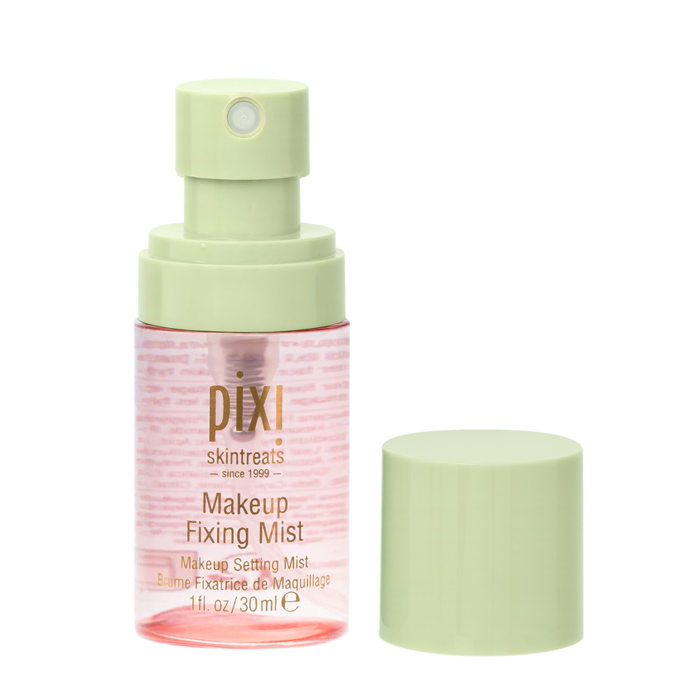 Pixi Skintreats Makeup Fixing Mist in a clear bottle with a pale green spray pump, shown next to its matching light green cap on a white background. view 2